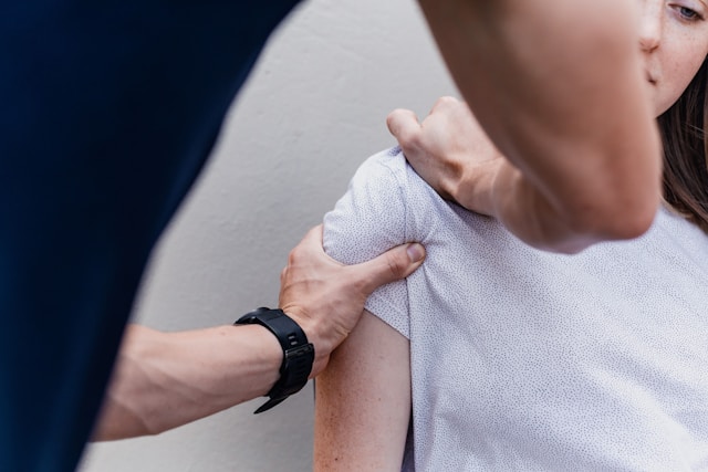 Close crop of hands-on chiropractic work on a patient's shoulder